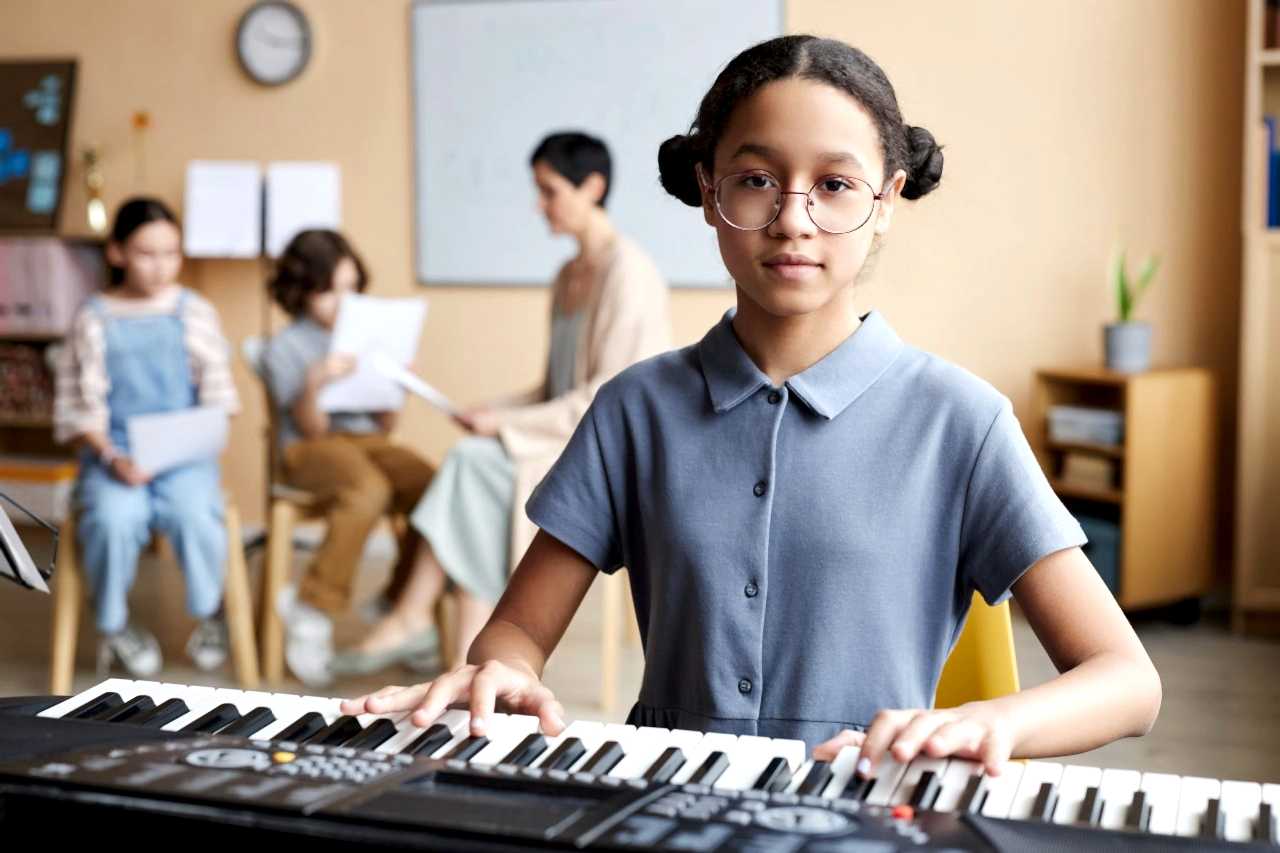 Schoolgirl playing piano in music class