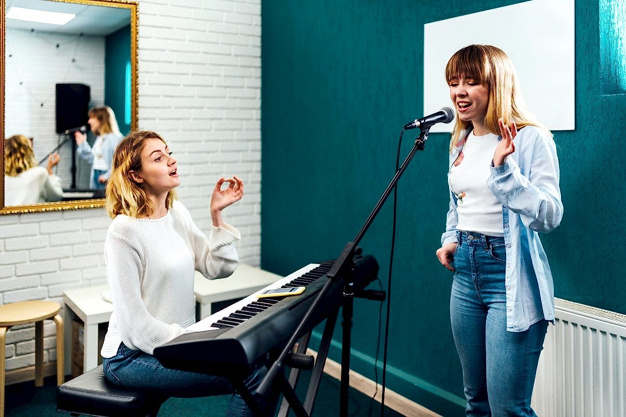 Vocal coach training her student's voice on a lesson
